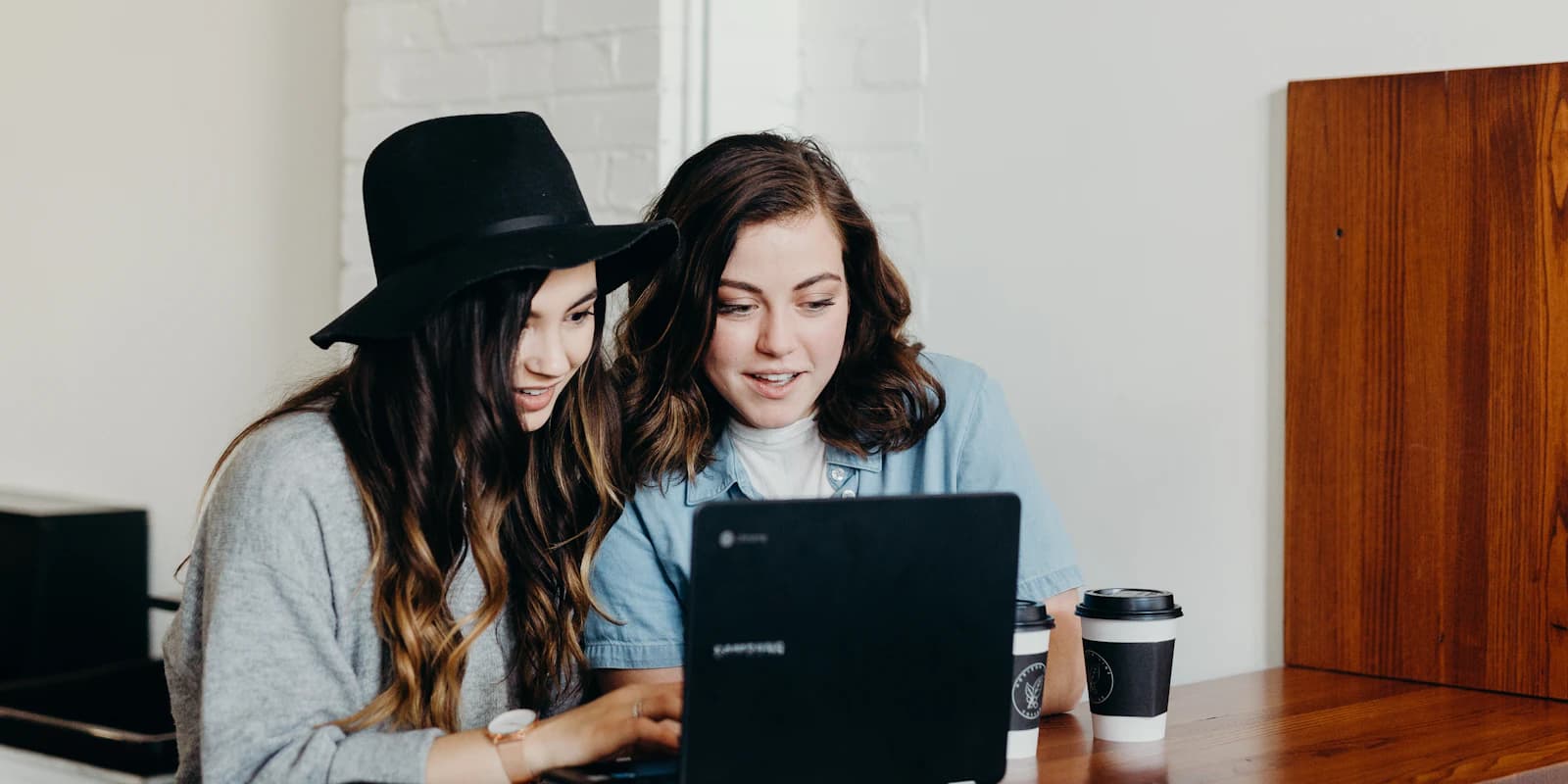Two evaluators reviewing the same work together on one laptop and comparing their reads