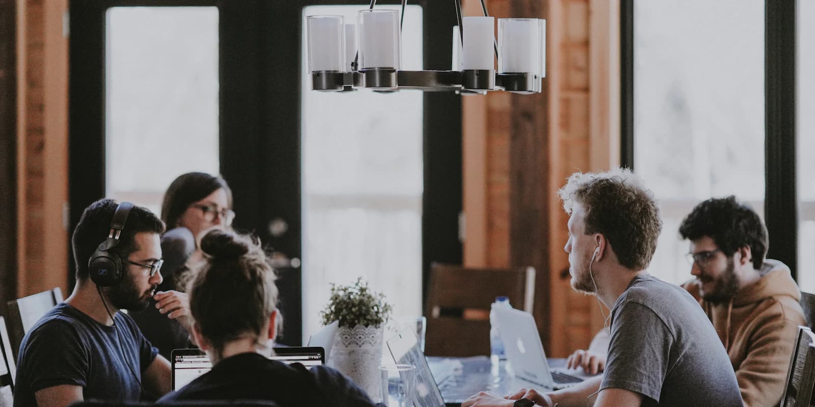A cross-functional team collaborating around a table, building capability through real work